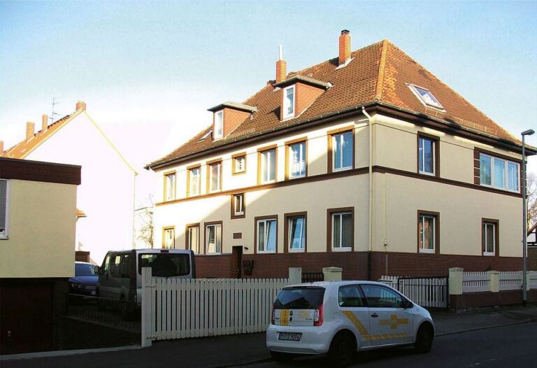 Saniertes Wohnhaus mit weißem Zaun an der Stammestraße
